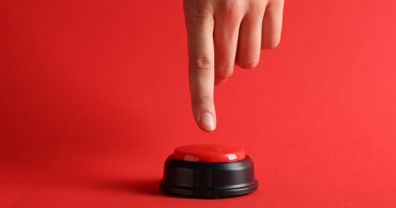 Hand pressing a red button